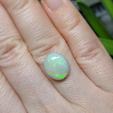 Opal ring on a hand with a blurred background