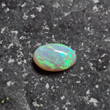 Opal stone on a dark, textured surface