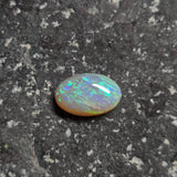 Opal stone on a dark, textured surface