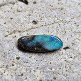 Blue opal stone on a textured beige surface