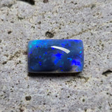 Blue opal stone on a textured gray surface