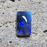 Blue opal stone on a textured gray surface