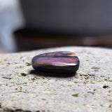 Multicolored stone on a textured stone surface