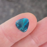 Blue gemstone on a finger with a blurred background