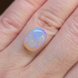 Opal stone on a person's finger
