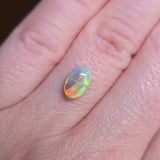 Opal gemstone on a person's finger