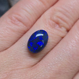 Blue opal stone held between fingers