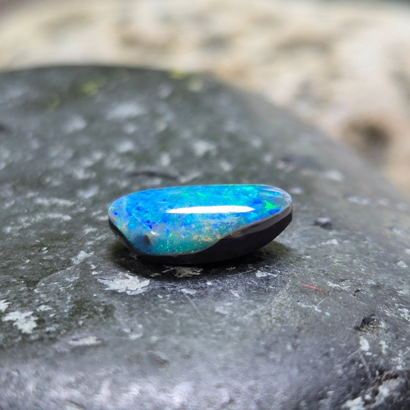 Blue opal stone on a dark stone surface