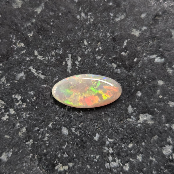 Opal stone on a dark, textured surface