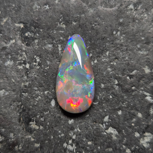 Multicolored opal stone on a dark gray background
