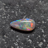 Multicolored opal stone on a dark textured background