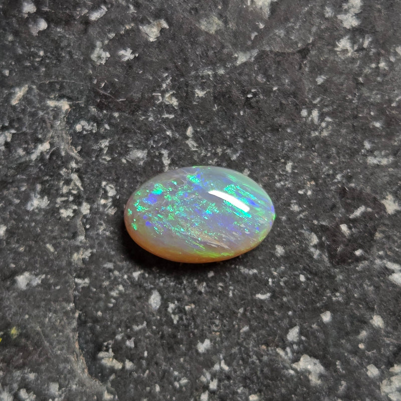 Opal stone on a dark, textured surface