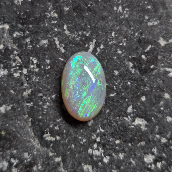 Opal stone on a dark textured surface