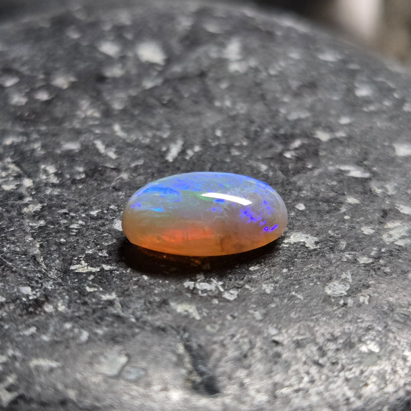 Opal stone on a dark stone surface