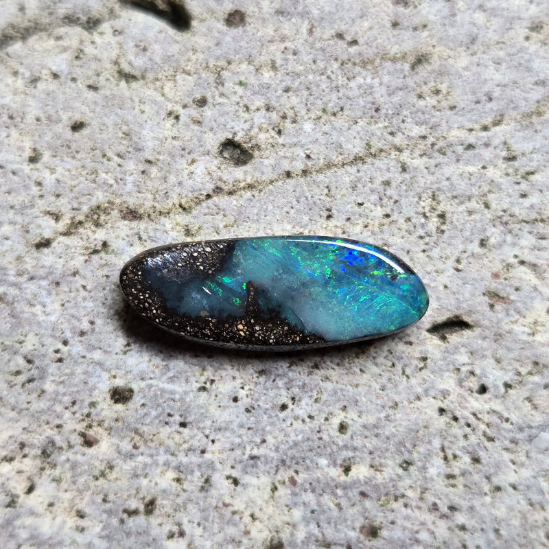 Blue opal stone on a textured beige surface