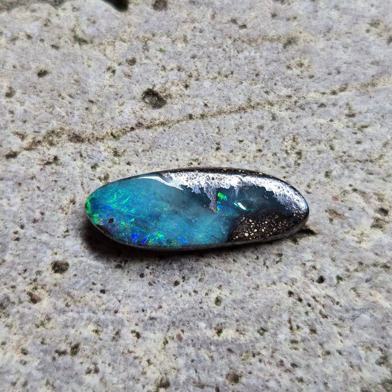 Opal stone on a textured concrete surface