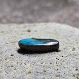 Blue and black stone on a textured stone surface