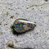 Opal stone on a textured gray surface