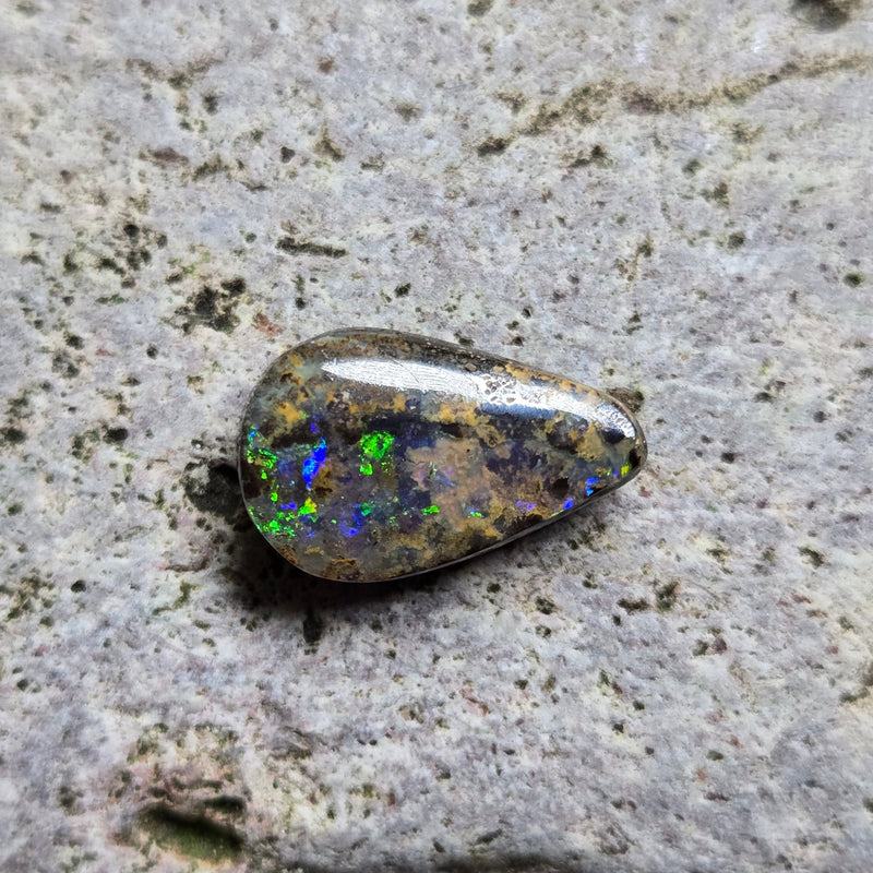 Opal stone on a textured gray surface