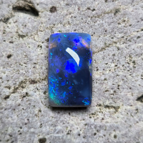 Blue opal stone on a textured beige surface