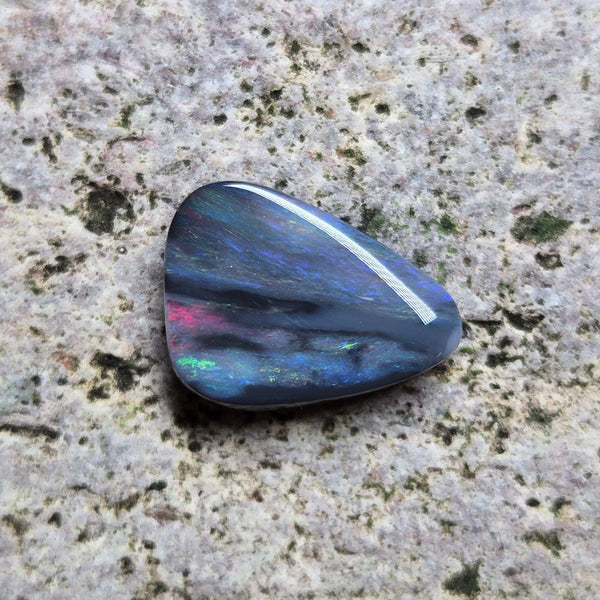 Multicolored stone on a textured stone surface