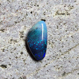 Blue opal stone on a textured gray surface