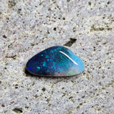 Blue opal stone on a textured gray surface