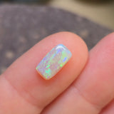 Opal stone on a finger with a blurred background