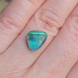 Multicolored gemstone on a person's finger